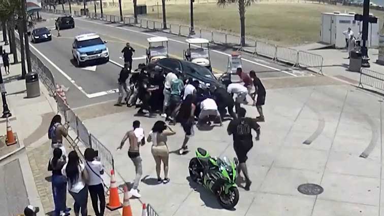 南卡一摩托车骑手被轿车碾压  群众合力推车救人